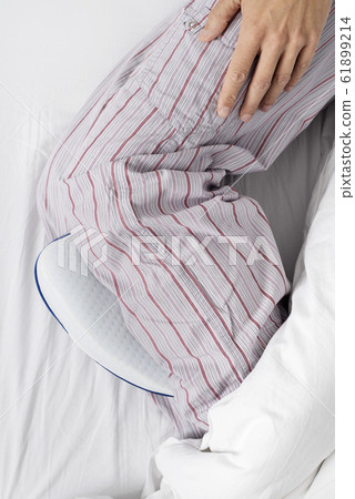 man in bed using an anatomical leg cushion man in bed using an anatomical leg cushion 61899214