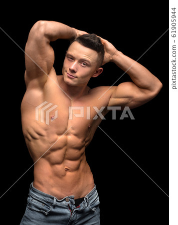 Fitness male model standing on dark background Fitness male model standing on dark background 61905944