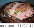 Assortment of tasty and delicious Italian  antipasto charcuterie delicatessen. Parma ham, Chorizo, Salami with pickles on wooden plate.  61909414