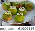 Tasty Mini Green Tea Choux au Craquelin  or French Crunchy Cream Puff filled with delicious and creamy Chantilly Cream on white plate. 61909416