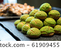 Tasty Mini Green Tea Choux au Craquelin or French Crunchy Cream Puff filled with delicious and creamy Chantilly Cream.  61909455