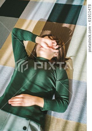 Woman lying down in living room fatigue break 61911478