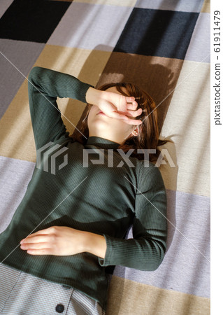 Woman lying down in living room fatigue break 61911479