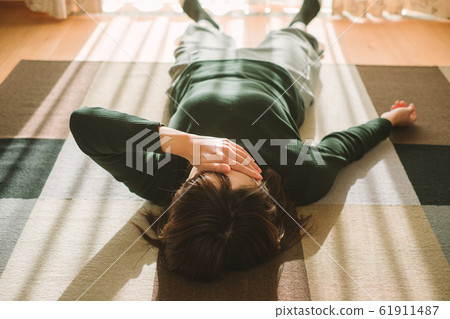 Woman lying down in living room fatigue break 61911487