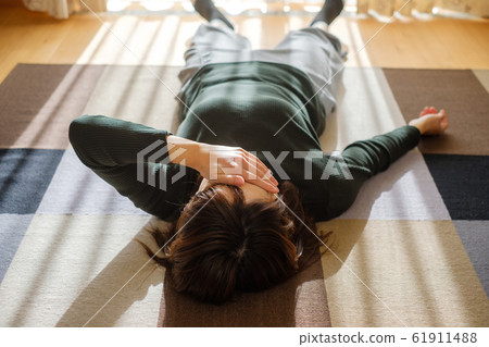 Woman lying down in living room fatigue break 61911488