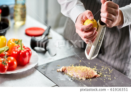 Chief chops and marinates chicken. Professional chef in a kitchen of restaurant cooking. Chief chops and marinates chicken. Professional chef in a kitchen of restaurant cooking. 61916351