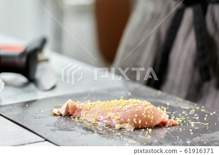 Chief chops and marinates chicken. Professional chef in a kitchen of restaurant cooking. 61916371