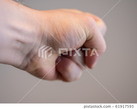 A man's fist punching into copy space A man's fist punching into copy space 61917593