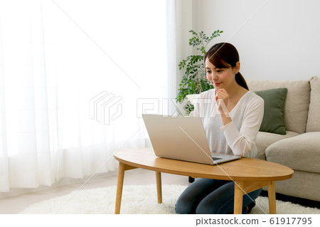Woman operating a personal computer 61917795