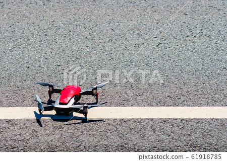 Drone start to flying from road 61918785