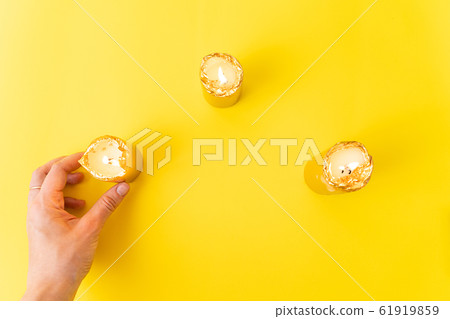 Hand with golden candles on yellow background. Wellnes, magic, relax concept. Copy space Hand with golden candles on yellow background. Wellnes, magic, relax concept. Copy space 61919859