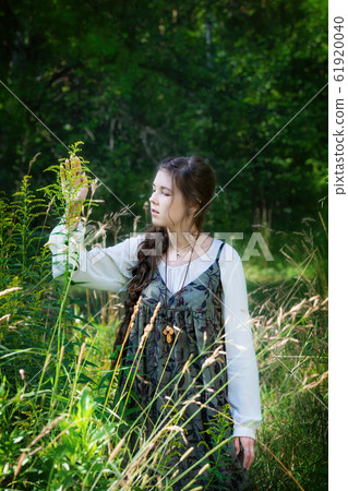 Woman herbalist collects medicinal herbs 61920040