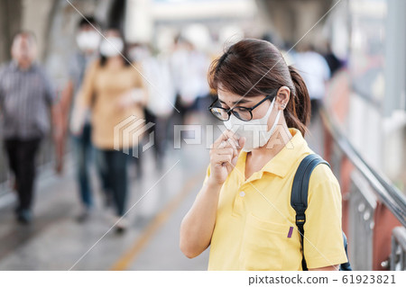 young Asian woman wearing protection mask against young Asian woman wearing protection mask against 61923821
