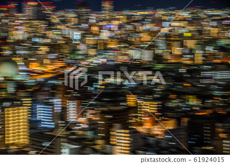 夜間平移穿過城市建築中一條縫隙的火車（強調尾燈）的鏡頭 61924015