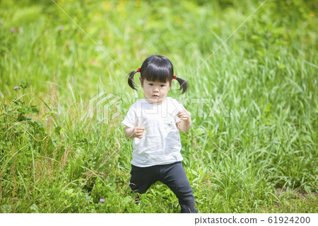 Girl playing in the field 61924200