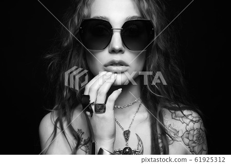 tattooed girl in sunglasses and jewelry 61925312