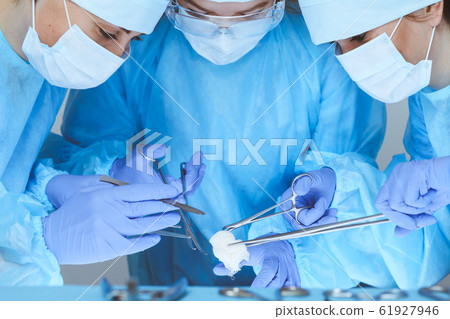 Close-up of medical team performing operation. Group of surgeons at work are busy of patient. Medicine, veterinary or healthcare and emergency in hospital Close-up of medical team performing operation. Group of surgeons at work are busy of patient. Medicine, veterinary or healthcare and emergency in hospital 61927946