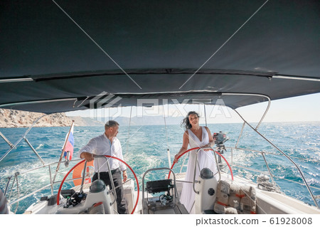 Family wedding couple on a sea voyage on a sailing yacht Family wedding couple on a sea voyage on a sailing yacht 61928008