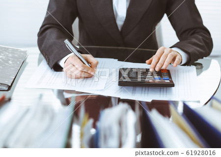 Bookkeeper woman or financial inspector making report, calculating or checking balance, close-up. Business, audit or tax concepts 61928016