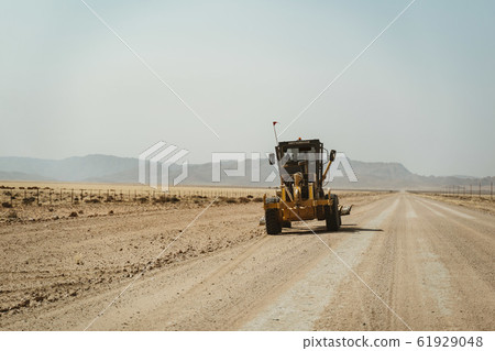 bulldozer grader working on a gravel road in Africa 61929048