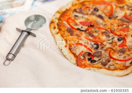 Pizza and pizza cutter close up a Pizza and pizza cutter close up a 61930385