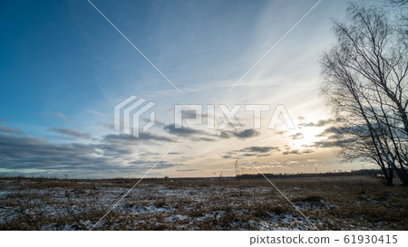 Beautiful setting sun over frozen field 61930415