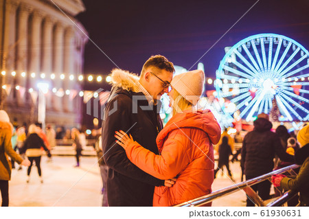 couple hugging in Saint Valentine's Day. Young romantic pair having fun outdoors in winter. St. Valentines Day at city ice rink. New Year holidays. active date ice skating on ice arena on Christmas 61930631