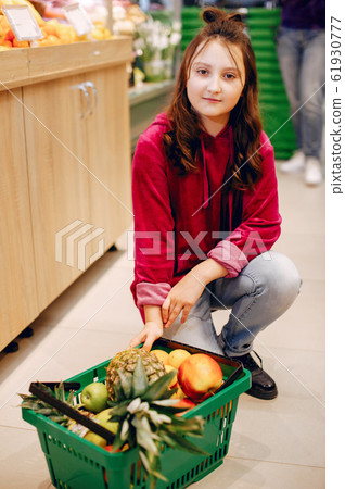 Cute little girl in a supermarket Cute little girl in a supermarket 61930777
