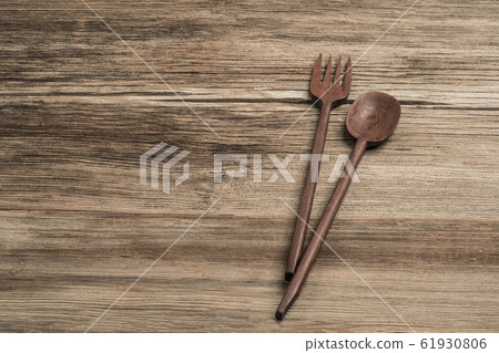 carved spoon and fork on a wooden table 61930806