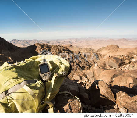 GPS navigator and backpack mountain top in desert 61930894