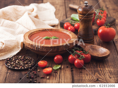 Wooden plate of creamy tomato soup with wooden Wooden plate of creamy tomato soup with wooden 61931666