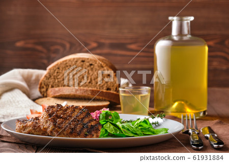 Grilled beef cutlet with fresh salad, brown bread Grilled beef cutlet with fresh salad, brown bread 61931884
