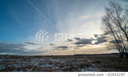 Beautiful setting sun over frozen field Beautiful setting sun over frozen field 61932297