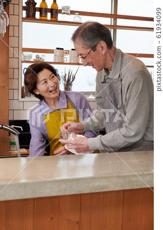 年長的夫婦一起在廚房裡洗 年長的夫婦一起在廚房裡洗 61934099