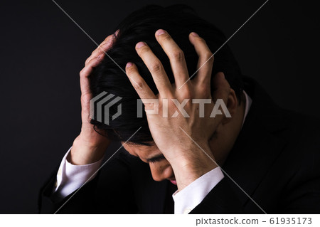 Office worker holding head (black background, young man, negative image) Office worker holding head (black background, young man, negative image) 61935173