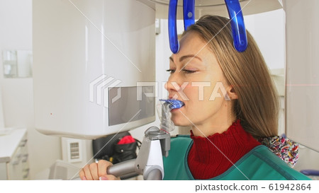 Doctor to take a image 3dx-ray machine 3d digital scanner tomography of teeth and jaw in modern laboratory dental clinic. Computer dental diagnostics. Doctor to take a image 3dx-ray machine 3d digital scanner tomography of teeth and jaw in modern laboratory dental clinic. Computer dental diagnostics. 61942864