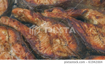 Fried grilled salmon on bbq. Marinade from white sauce and lemon. 61942884