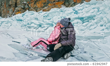 Couple has fun during winter walk against background of ice of f Couple has fun during winter walk against background of ice of f 61942947