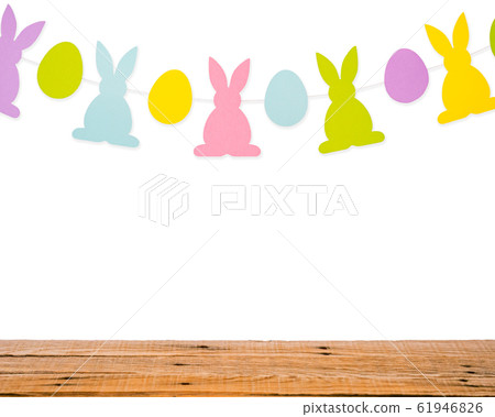 Wooden table and eggs and rabbits decoration garland on white wall. Easter holiday background Wooden table and eggs and rabbits decoration garland on white wall. Easter holiday background 61946826