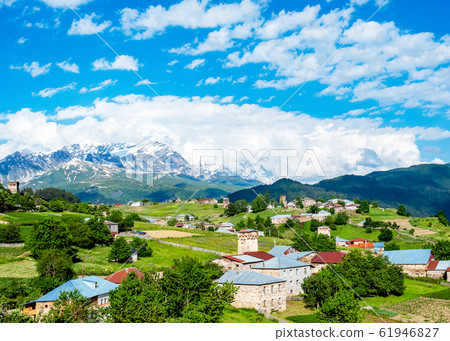 Village houses with towers on the background of Tetnuldi Mountain. Village houses with towers on the background of Tetnuldi Mountain. 61946827