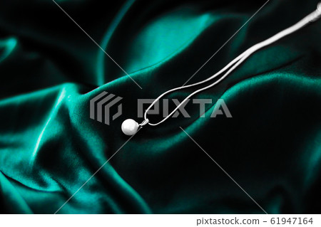 Luxury white gold pearl necklace on dark emerald Luxury white gold pearl necklace on dark emerald 61947164