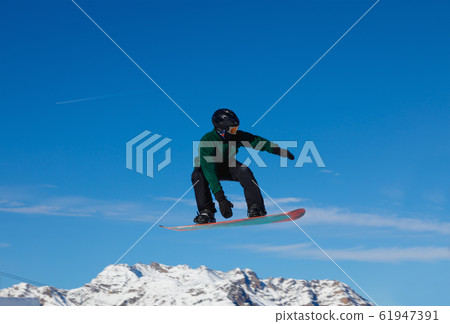 Snowboarder against the blue sky in Livigno, Italy Snowboarder against the blue sky in Livigno, Italy 61947391