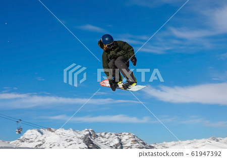 Snowboarder catches big air on a bright sunny day. Snowboarder catches big air on a bright sunny day. 61947392