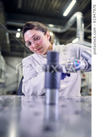 Young laboratory assistant in white coat with 3D printer on bokeh background Young laboratory assistant in white coat with 3D printer on bokeh background 61947976