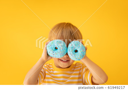 Happy child holding glazed donut Happy child holding glazed donut 61949217