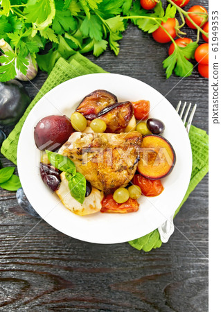 Chicken with fruits and tomatoes in plate 61949353