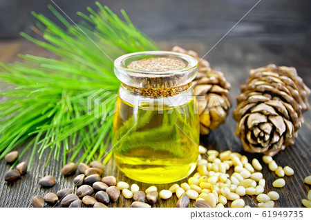 Oil cedar in glass jar on dark board 61949735