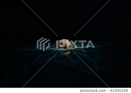 Fire on ice at night. Campground on ice. Tent stands next to bonfire. Lake Baikal. Nearby there is car. Shelter tent and ice are illuminated from the inside. Beautiful bonfire on real cracked ice. 61950109