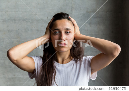Young Woman with Hands on Temples 61950475