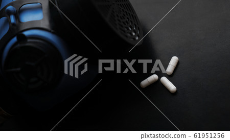 Epidemic and virus concept, white pills and Respirator on black background 61951256